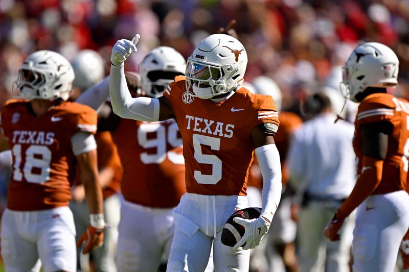 Oct 11, 2025; Dallas, Texas, USA; Texas Longhorns defensive back Malik Muhammad (5) celebrates after he intercepts a pass thrown by Oklahoma Sooners quarterback John Mateer (not pictured) during the first half at the Cotton Bowl. Mandatory Credit: Jerome Miron-Imagn Images