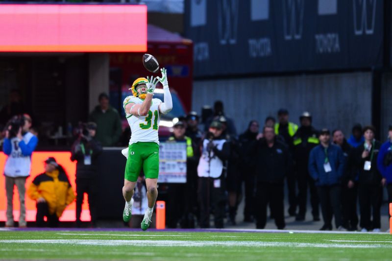 Nov 29, 2025; Seattle, Washington, USA; Oregon Ducks defensive back Dillon Thieneman (31) intercepts a pass against the Washington Huskies during the second half at Husky Stadium. Mandatory Credit: Steven Bisig-Imagn Images