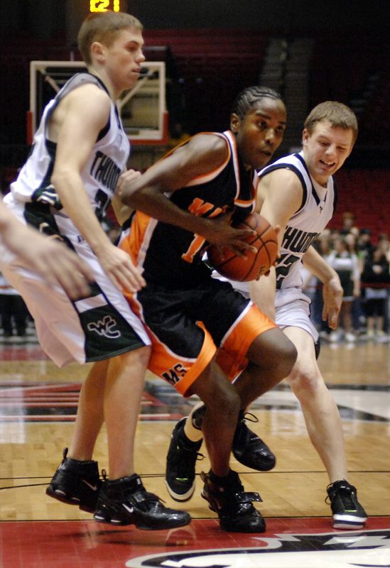 Manual's Paris Gulley drives past Savanna West Carroll defenders in a boys basketball supersectional at the Convocation Center on the NIU campus in DeKalb in 2008.