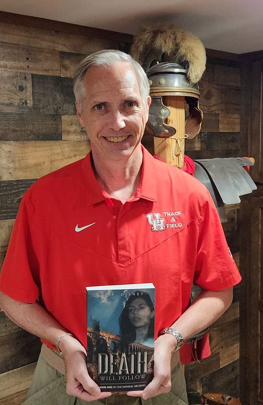 Local author B.P. Disney holds up a copy of "Death Will Follow," the first book in his Imperial Archives series.