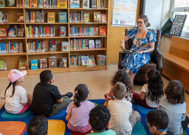 Teacher Gillian Tillo reads to preschoolers May 5 in the library at the Worcester Dual Language Magnet School.