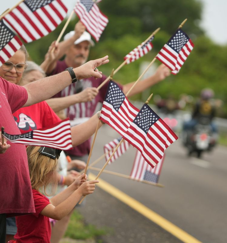 Supporters wave American flags as the Vietnam Traveling Memorial Wall passes by in Rockledge, on its way to the 38th annual All Veterans Reunion at Wickham Park.