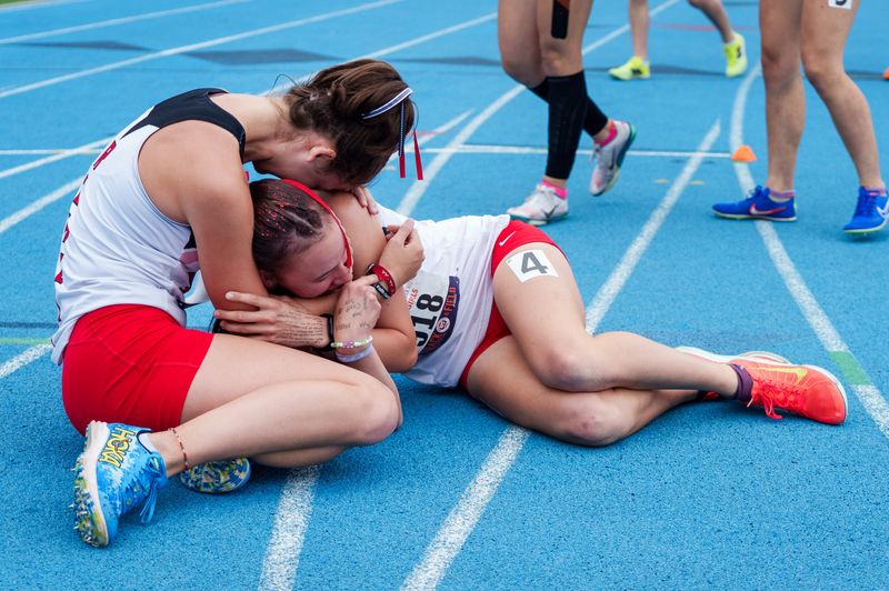 Stark County’s Paytin Terwilliger, left, gets down on the track to hug teammate and 4X800-relay anchor Dusti Smith who came from behind to win the event Saturday, May 23, 2026 at the IHSA Class 1A State Track and Field Championships at Eastern Illinois University in Charleston. MATT DAYHOFF/JOURNAL STAR