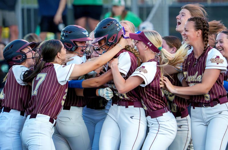 The Dunlap Eagles mob teammate Sutton Centoni, middle, after her walk-off game-winning hit against Providence Catholic in the seventh inning of their Class 3A softball supersectional Monday, June 1, 2026 at EastSide Centre in East Peoria. The Eagles will face Antioch at 10 a.m. Friday in the state semifinals.