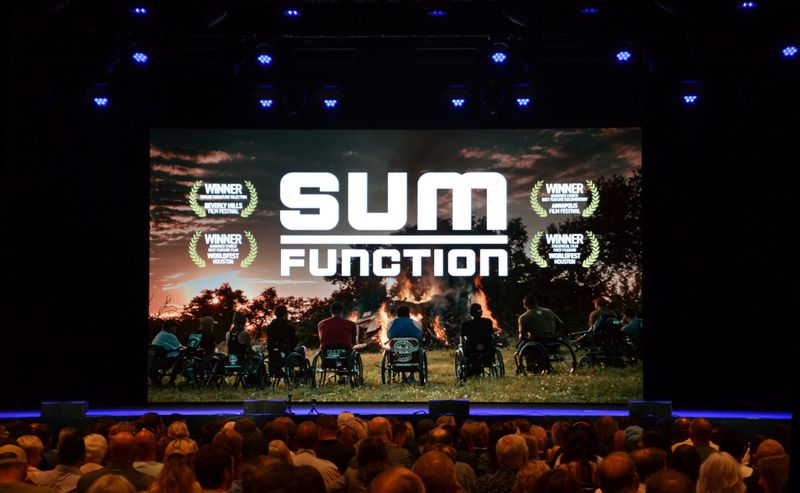 A few hundred people attend a May 30, 2026, hometown premiere of "Sum Function" at Hard Rock Casino Rockford. The film tells the story of disabled veterans and the Oscar Mike Foundation.