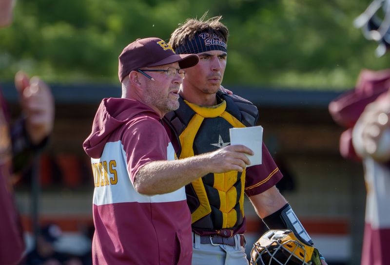 East Peoria head coach Matt Plummer talks with catcher RJ Duncheon between innings as the Raiders battle Metamora in a Class 3A baseball sectional semifinal Wednesday, June 3, 2026 at Washington Community High School. The Raiders advanced to the title game with a 1-0 win over the Redbirds.