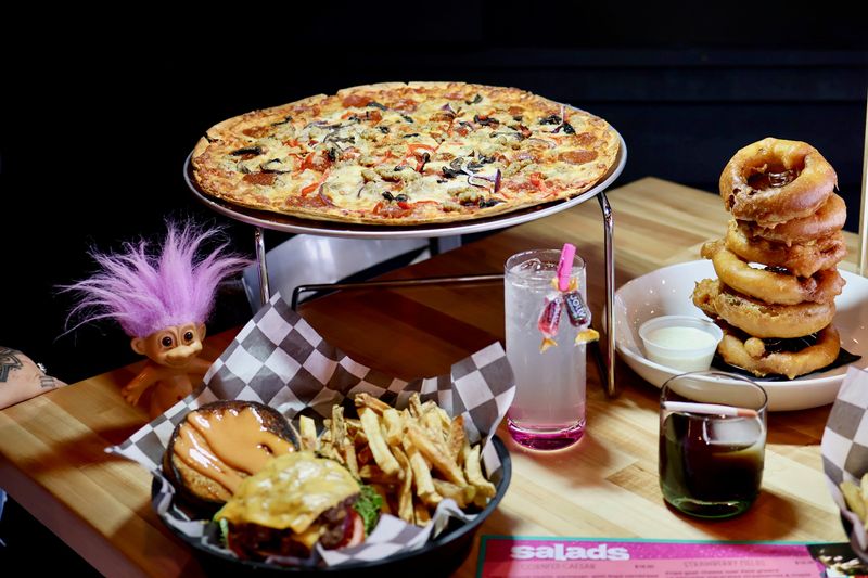 A pizza, onion rings, burgers and order of fries from The Spot is seen in an undated photo in Springfield. The recently opened bar is '90s themed.