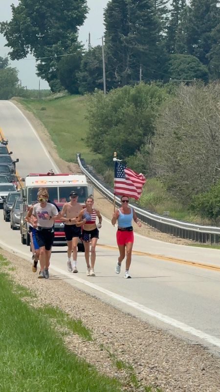 Nicole Roberts, right, carries the U.S. flag through Logan County during her leg of Relay for America, a non-stop flag carry from San Francisco to Washington, D.C. in honor of the nation's 250th birthday.