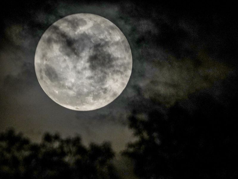 Clouds appear to drift by full pink moon seen from Anderson, SC, Wednesday, April 1 2026.