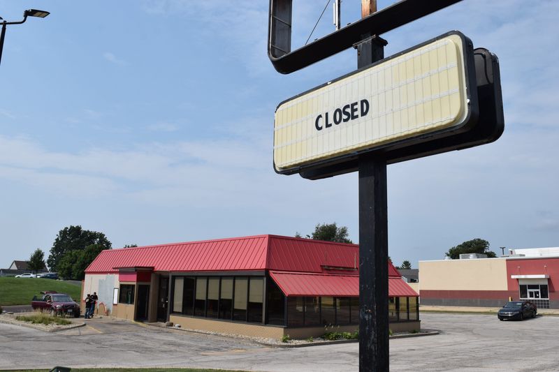 A crew paints over the star-shaped logo at Hardee's at 1102 Peoria St. in Washington. The location, along with two other Peoria spots, has closed.