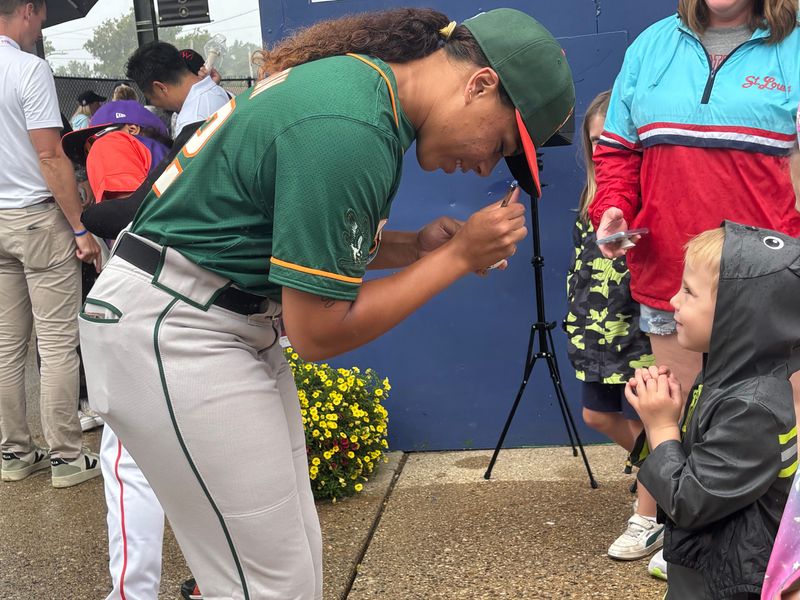 Sabrina Robinson of the Boston Hunters signs a baseball for Finnegan Caul, 4, of St. Louis, Missouri, prior to the inaugural game of the Women's Pro Baseball League at Robin Roberts Stadium in Springfield, Ill., Aug. 1, 2026. It was the first time a women's pro league has staged a game in over 70 years.