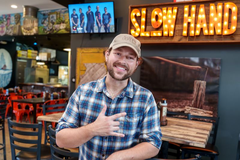 Seth Boyer flashes the hand gesture he uses in his social media videos, meaning "I Love You" in American Sign Language. Boyer has earned a strong following on social media thanks to his unique and entertaining food review videos. Slow Hand BBQ in Peoria Heights is one of his favorites.