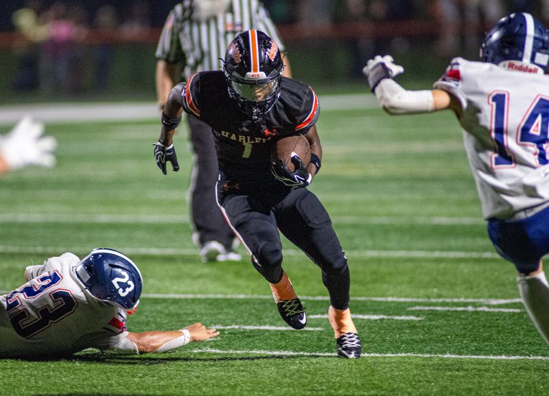 Harlem's Tykeese Duncan finds a hole in the Belvidere North defensive line during their game at Harlem High School on Friday, Aug. 21, 2026.