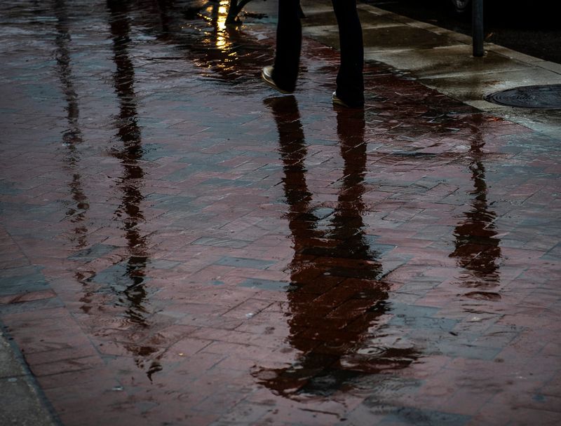 A woman walks down Kirkwood Avenue under an umbrella on Thursday, March 23, 2023.