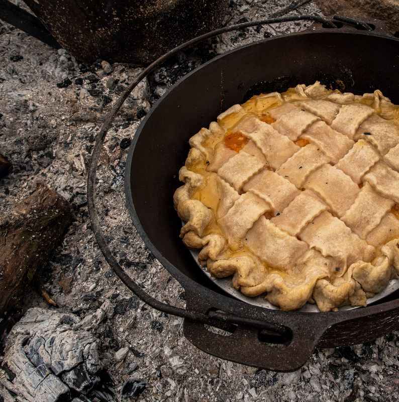 A latticed pie by Louise Miracle sits over a fire outside her home.