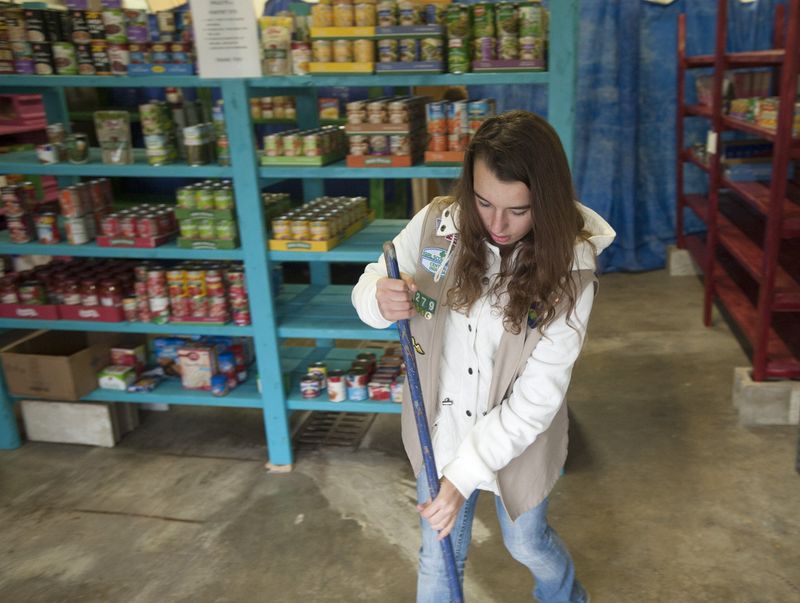 Destini-Noel Arnett sweeps the floor in Pantry 279, a food pantry operated by Cadette Girl Scout Troop 69-279 in Ellettsville, on Nov 16, 2015. What began as a Girl Scout troop service project has grown into a full-fledge food pantry serving hundreds of people each month.