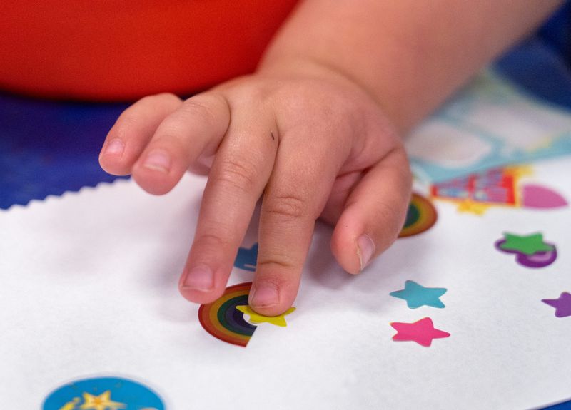 A child creates art with stamps at Carmel Clay Edu-Care, Thursday, May 18, 2023 at Clay Middle School.  The district offers childcare for its employees.