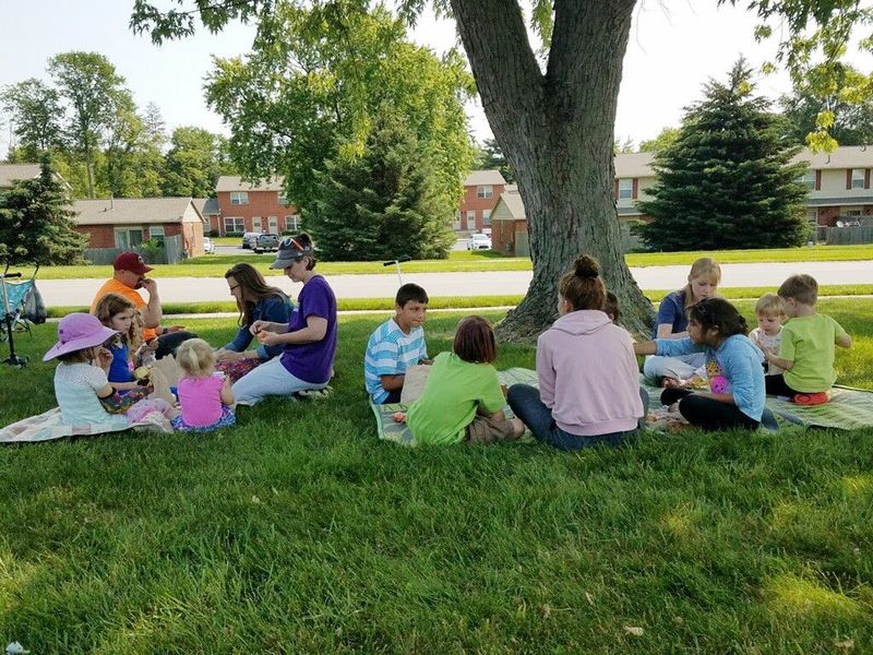 Kids and their families share a meal in the shade as part of the summer food service program a couple years ago in Bloomington. The program will be offered again this summer at 10 locations.