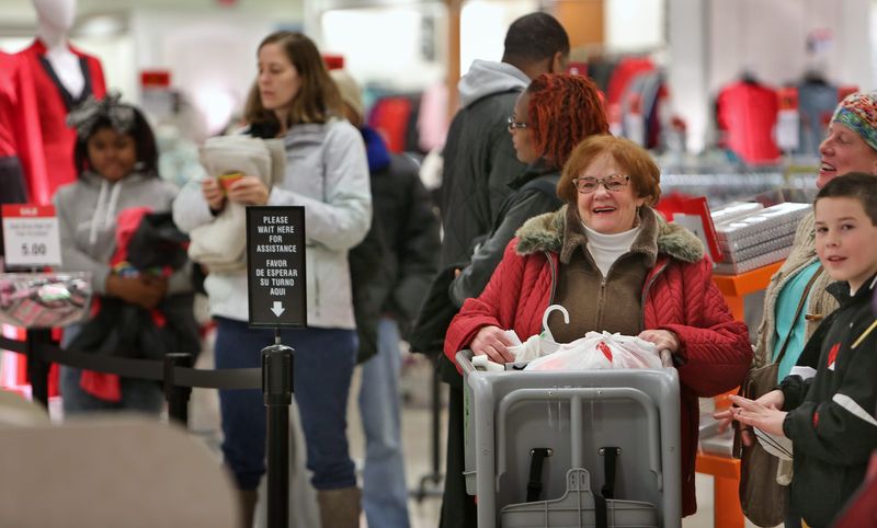 Kathy Salem, red coat, is all smiles in the checkout line at JCPenney at 8752 N. Michigan Rd., during Black Friday shopping with her daughter Kimberly Deck and grandson Fife Deck, November 28, 2014.