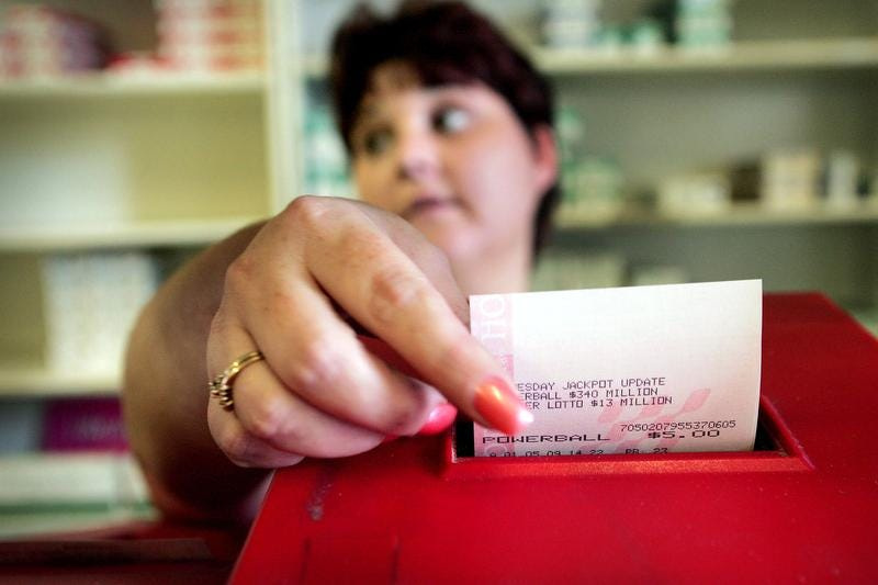A clerk rings up Powerball lottery tickets for customers.