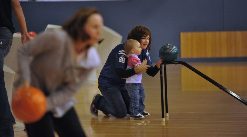 Danielle Stanley of Carmel, helps daughter Madeline, 23 months old, roll a bowling ball off a stand as former Indianapolis Colt, six-time Pro Bowl center and current ESPN analyst Jeff Saturday and his wife Karen hosted SuperBOWL for Saturday's Kids at Pinheads Bowling in Fishers Monday October 28, 2013. The annual celebrity bowling tournament will benefit The People's Burn Foundation a local, national-recognized nonprofit that supports burn survivors and their families through camp and therapeutic activities. Camp Saturday is a week long residential camp designed for children ages 5 to 18 who have survived burn injuries.