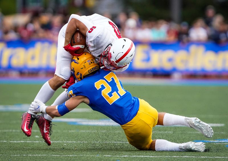 Center Grove Trojans wide receiver Harrison Stomps (10) is tackled by Carmel Greyhounds cornerback Kyle Fedorcha (27) on Friday, September 3, 2021, at Carmel High School in Carmel. Center Grove Trojans defeated the Carmel Greyhounds, 41-14