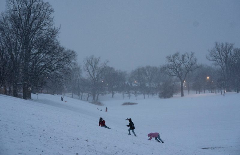 Kids play on a large hill Thursday, Feb. 3, 2022, at Brookside Park in Indianapolis. A winter storm traveled through Indianapolis bringing first rain, sleet, and snow.