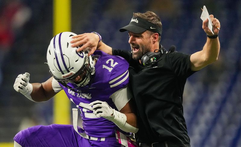 Ben Davis Giants linebacker Andrew Evans (12) celebrates with Ben Davis Giants head coach Russ Mann on Saturday, Nov. 25, 2023, during the IHSAA Class 6A football state championship game at Lucas Oil Stadium in Indianapolis. The Ben Davis Giants lead at the half against the Crown Point Bulldogs, 10-3.