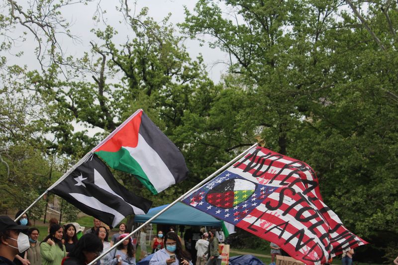 A Palestinian flag and a flag that reads 'no peace on stolen land' are flown at the pro-Palestine encampment in Dunn Meadow on April 29, 2024.