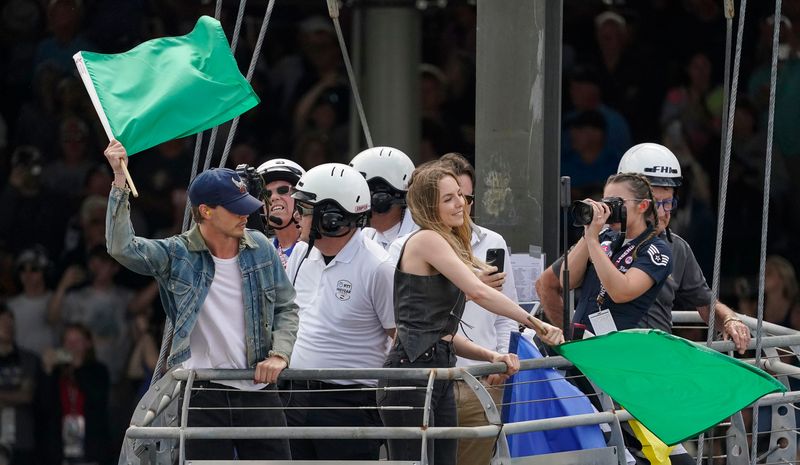 Austin Butler and Jodie Comer wave the green flag to start the race Sunday, May 26, 2024, ahead of the 108th running of the Indianapolis 500 at Indianapolis Motor Speedway.