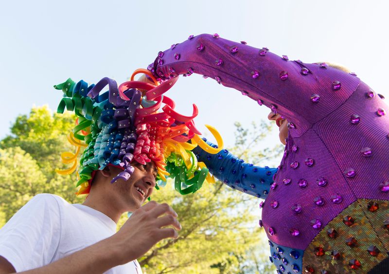 Patience, right, puts her hat on Vraj Patel while she performs during Pride First Friday in Haynie's Corner Arts District in Evansville, Ind., Friday, June 7, 2024.