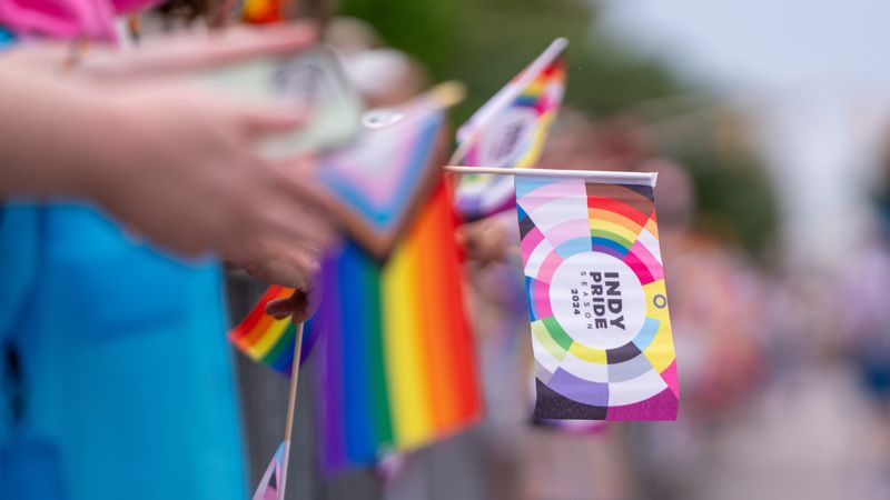 A parade spectator holds an Indy Pride Parade flag, June 8, 2024, during the Indy Pride Parade on Massachusetts Avenue in Indianapolis, Indiana.