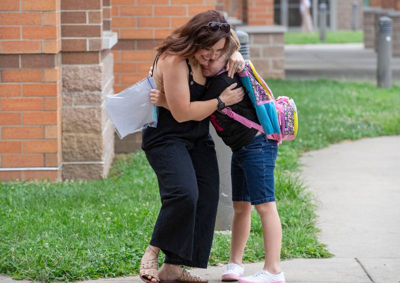 Teaching assistant Brittany Nutt, left, hugs third grader Layla Cameron on the first day of school at Newburgh Elementary School in Newburgh, Ind., Wednesday, August 7, 2024.