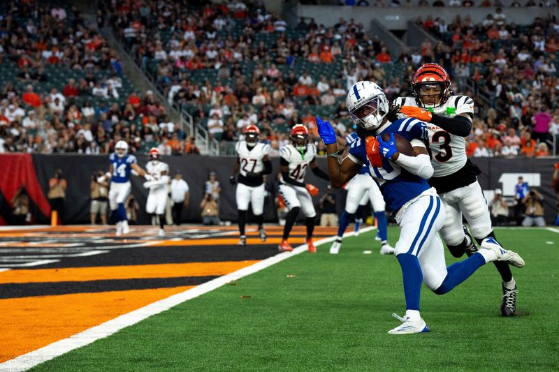 Indianapolis Colts wide receiver Adonai Mitchell (10) scores a touchdown as Cincinnati Bengals safety Daijahn Anthony (33) attempts to stop him in the first quarter at Paycor Stadium in Cincinnati on Thursday, Aug. 22, 2024.