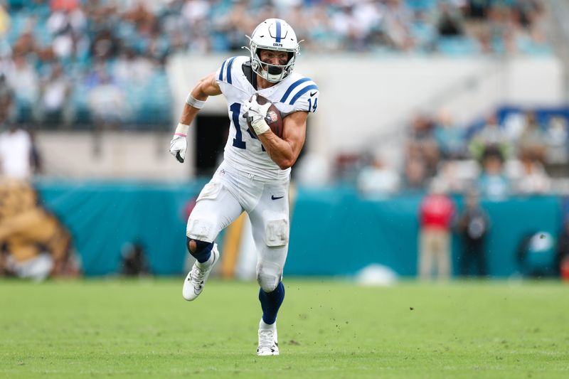 Oct 6, 2024; Jacksonville, Florida, USA; Indianapolis Colts wide receiver Alec Pierce (14) runs with the ball against the Jacksonville Jaguars in the fourth quarter at EverBank Stadium. Mandatory Credit: Nathan Ray Seebeck-Imagn Images