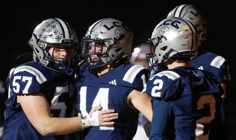 Central Catholic Knights Mason Meister (14) celebrates with teammates after scoring Friday, Nov. 1, 2024, during the IHSAA sectional semifinal football game against the Western Boone Stars at Central Catholic High School in Lafayette, Ind. Central Catholic won 28-20.