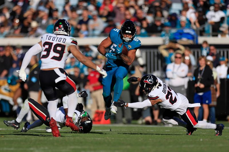 Houston Texans cornerback Kamari Lassiter (4) looks at a leaping Jacksonville Jaguars tight end Brenton Strange (85) as Houston Texans cornerback Myles Bryant (27) can’t make the stop and linebacker Henry To'oTo'o (39) looks on during the third quarter of an NFL football matchup Sunday, Dec. 1, 2024 at EverBank Stadium in Jacksonville, Fla. The Texans held off the Jaguars 23-20. [Corey Perrine/Florida Times-Union]