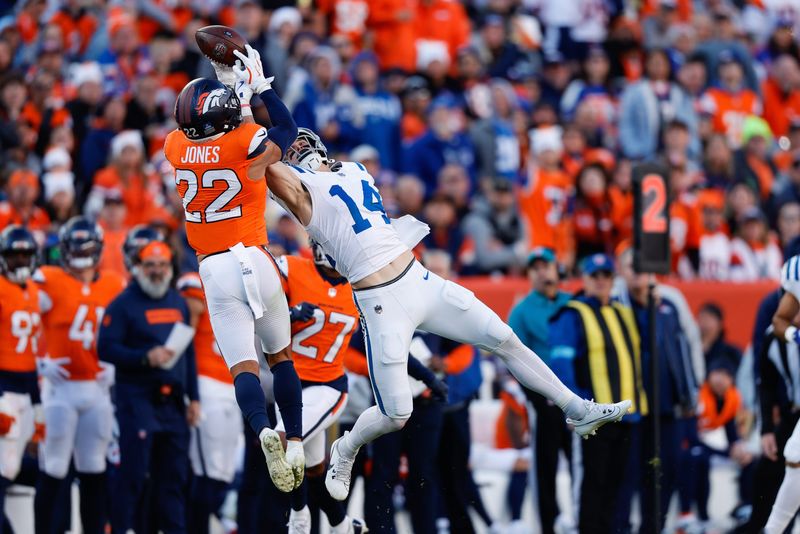 Dec 15, 2024; Denver, Colorado, USA; Denver Broncos safety Brandon Jones (22) intercepts a pass intended for Indianapolis Colts wide receiver Alec Pierce (14) in the second quarter at Empower Field at Mile High. Mandatory Credit: Isaiah J. Downing-Imagn Images