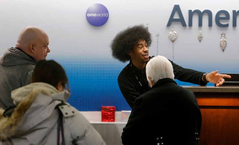 A ticket agent talks to passengers at the American Airlines desk Monday, Dec. 23, 2024, at South Bend International Airport.