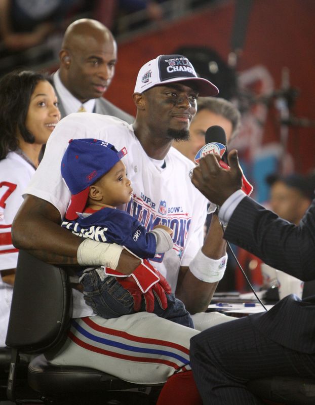 Feb 3, 2008; Glendale, AZ, USA; New York Giants wide receiver Plaxico Burress (17) with his 12-month old son Elijah is interviewed by after winning Super Bowl XLII at the University of Phoenix Stadium. New York Giants defeated the New England Patriots with a final of 17-14. Mandatory Credit: Matthew Emmons-USA TODAY Sports