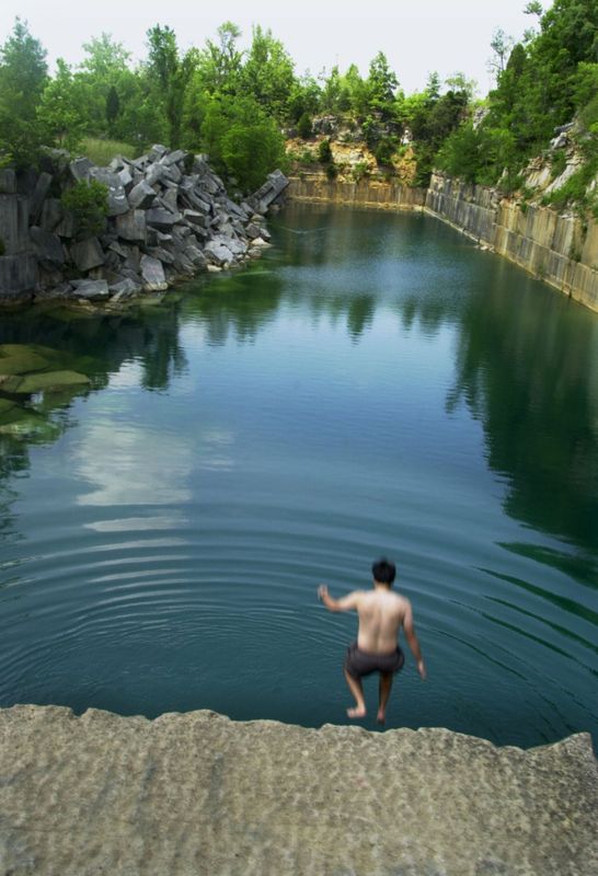 A swimmer jumps from the lip of Rooftop Quarry (formally Adams Quarry) in June 2001