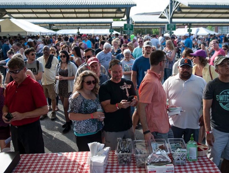 Event attendees line up at the Janko's Little Zagreb booth at the 2017 Taste of Bloomington in downtown Bloomington.