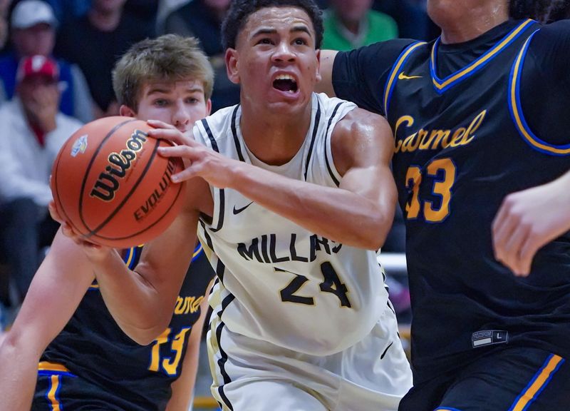 Noblesville’s Baron Walker shoots a wild shot and scores under the hoop during the IHSAA boys basketball Class 4A sectional between the Carmel Greyhounds and the Noblesville Millers at Carmel High School on Tuesday, March 4, 2025, in Carmel Ind. Carmel Players, Ben Bremer (13) and Liam Mann (33).