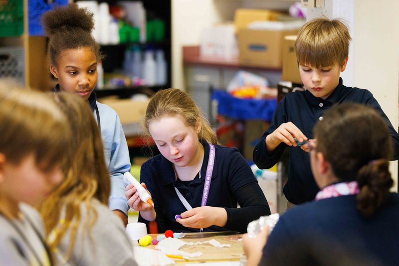 Adelyn Sachau, center, a fourth-grade student at Kennedy Academy, works with a team of her classmates to construct a hat for a model skeleton during a class on Tuesday, Feb. 25, 2025, in South Bend.