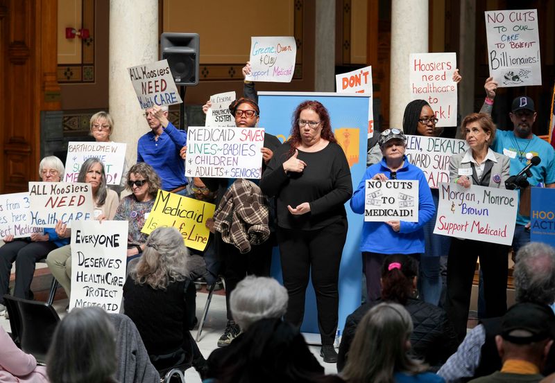 Attendees hold signs during a rally and press conference protesting proposed cuts to Medicaid in Indiana on Tuesday, April 1, 2025, at the Indiana Statehouse in downtown Indianapolis.