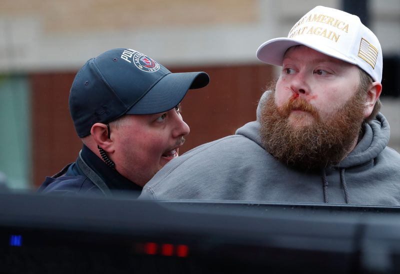 A man is handcuffed by police officers after an altercation with protesters Saturday, April 5, 2025, during the Remove! Reverse! Reclaim! protest in Lafayette, Ind.