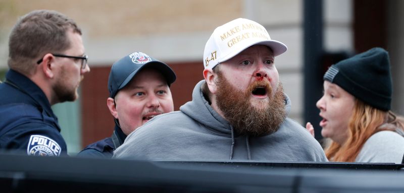 A man is handcuffed by police officers after an altercation with protesters Saturday, April 5, 2025, during the “Remove! Reverse! Reclaim!” protest in Lafayette, Ind.
