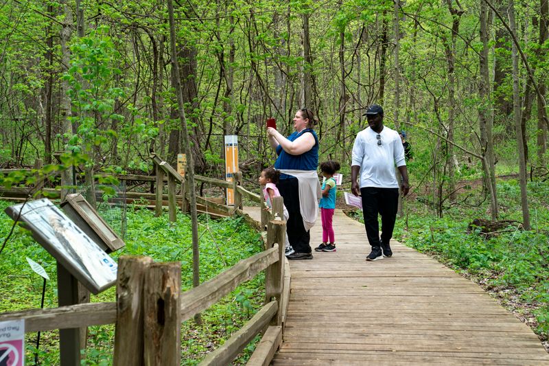 People hike the trails during Earth Day at Wesselman Woods Nature Preserve Saturday, April 19, 2025.