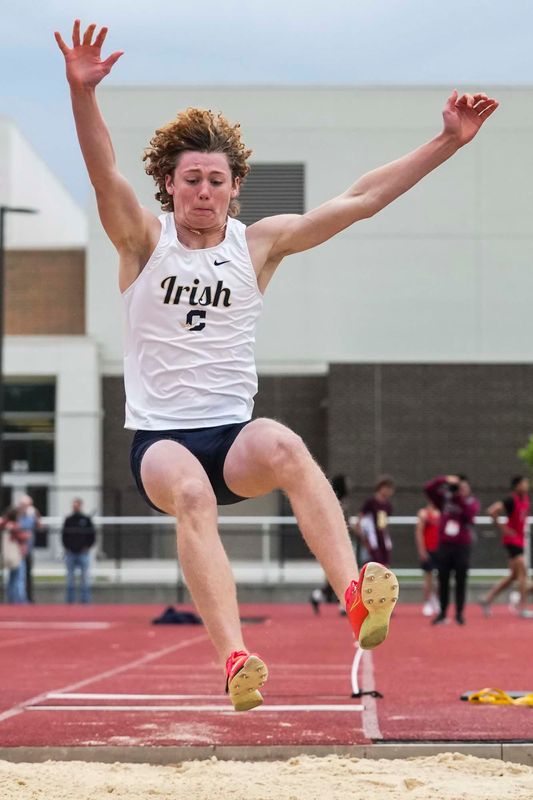 Cathedral’s Evan Johnson attempts a long jump Thursday, May 22, 2025, during a boys track and field sectionals meet at Lawrence Central in Indianapolis.