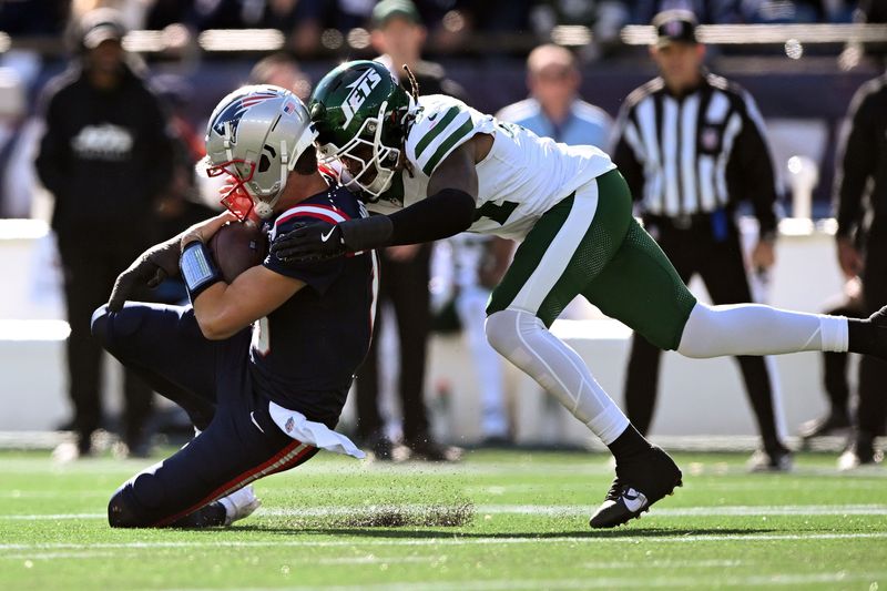 Oct 27, 2024; Foxborough, Massachusetts, USA; New England Patriots quarterback Drake Maye (10) is tackled by New York Jets linebacker Jamien Sherwood (44) during the first half at Gillette Stadium. Mandatory Credit: Brian Fluharty-Imagn Images
